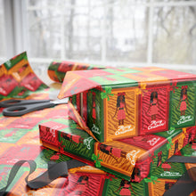 Load image into Gallery viewer, Colorful Christmas-themed gift boxes stacked on a table with scissors.